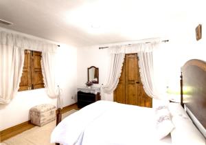 ラメーゴにある3 bedrooms villa with city view private pool and enclosed garden at Lamego 3 km away from the beachの白いベッドルーム(ベッド1台、鏡付)