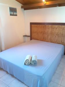 a bedroom with a bed with two towels on it at Appartement confortable à Saint-Paul 70 m² avec piscine partagée in Saint-Paul