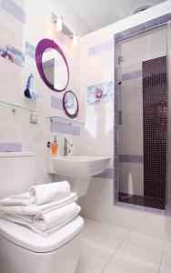 ein Badezimmer mit einem Waschbecken, einem WC und einem Spiegel in der Unterkunft Annabelle отель in Odessa