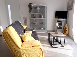 ein Wohnzimmer mit einem Sofa und einem Tisch in der Unterkunft Maison de 2 chambres avec jardin clos et wifi a Pujaut in Pujaut