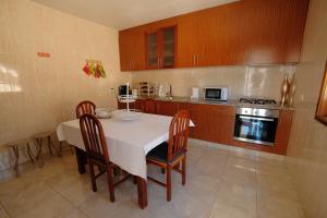 y cocina con mesa, sillas y fogones. en 4 bedrooms house with city view balcony and wifi at Santa Maria da Feira, en Aveiro
