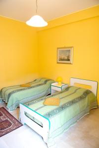 two beds in a room with yellow walls at 2 bedrooms appartement with terrace at Vita in Vita