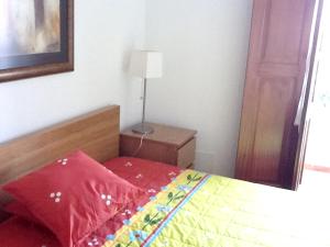 a bedroom with a bed with a red comforter at 2 bedrooms house with enclosed garden and wifi at Aljezur 8 km away from the beach in Aljezur