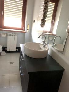 La salle de bains est pourvue d'un lavabo et de 2 fenêtres. dans l'établissement 3 bedrooms appartement with city view and balcony at Cosenza, à Cosenza