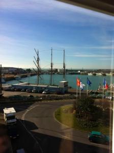 a view of a harbor with flags and a marina at Appartement d'une chambre avec vue sur la mer et wifi a Granville in Granville