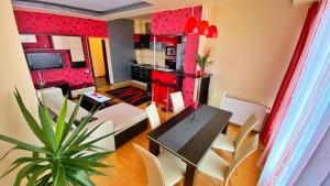 a living room with red walls and a table and chairs at Mamaia Nord Apartament in Mamaia Sat/Năvodari
