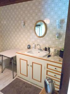 ein Bad mit einem Waschbecken und einem Spiegel in der Unterkunft Maison de 4 chambres avec piscine privee jardin amenage et wifi a Marquay in Saint-André-dʼAllas