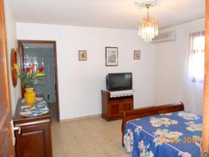 a room with a bed and a tv and a table at Appartement moderne à Sainte-Anne avec jacuzzi - 48 m². in Sainte-Anne