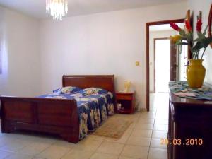 a bedroom with a bed and a table with a vase on it at Appartement moderne à Sainte-Anne avec jacuzzi - 48 m². in Sainte-Anne