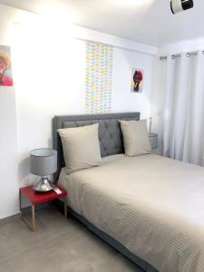 een slaapkamer met een bed en een rode nachtkastje bij Maison de 2 chambres avec vue sur la mer piscine partagee et jardin clos a La Trinite a 2 km de la plage in La Trinité