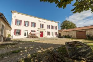 a large white building with a red door at Maison accueillante à Mouterre-Silly avec jardin et cheminée in Mouterre-Silly