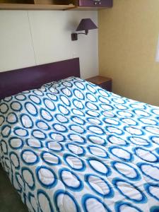 Una cama con una manta azul y blanca encima. en Maison accueillante à Biscarrosse avec piscine et jardin, en Biscarrosse