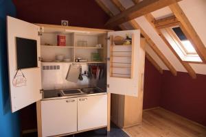 una pequeña cocina con armarios blancos y una ventana en Charming studio in Peniche – Sea view 40 m², en Peniche