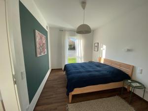 a bedroom with a bed with a blue blanket at Ferienwohnung Zum Kiessee in Schwarmstedt