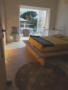 una cama en una habitación con una ventana grande en Maison charmante au Moule avec jacuzzi, en Le Moule