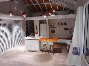 cocina con fregadero y encimera con taburetes en Maison charmante au Moule avec jacuzzi, en Le Moule 5 fotos más