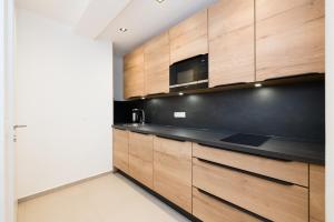 a kitchen with wooden cabinets and a microwave at Vienna Stay Apartments Linzerstrasse in Vienna