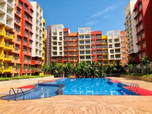 a swimming pool in front of some apartment buildings at Birdsnest Seaview Holiday Home in Dabolim
