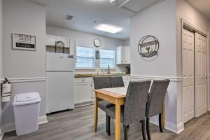 a kitchen with a table and chairs and a refrigerator at Downtown Ocean Springs Duplex with AandC 1 Mi to Beach in Ocean Springs
