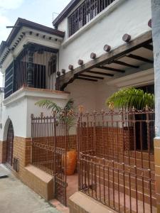 una recinzione di fronte a una casa con piante di Villa del Prado a Medellín