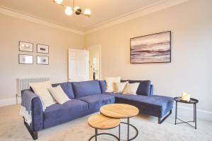 een woonkamer met een blauwe bank en een tafel bij Host & Stay - Huntcliff View Apartment in Saltburn-by-the-Sea