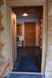um corredor com uma porta de madeira e um tapete azul em Chalet-Enzian-Bayerwald em Arnbruck