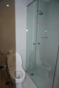 a bathroom with a toilet and a glass shower at Hotel Brothers in Solo