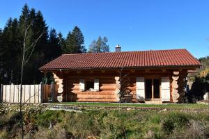 a log cabin with a red roof at Chalet-Enzian-Bayerwald in Arnbruck