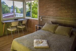 Un dormitorio con una cama, un escritorio y ventanas. en El Cabure Complejo, en Villa Carlos Paz 139 fotos más