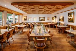 a restaurant with wooden tables and chairs at Walserhuus Sertig in Sertig Döfli