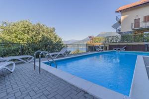 a swimming pool with chairs next to a building at Palma Romantic Dream in Perledo