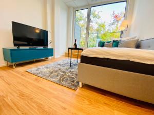 a bedroom with a bed and a flat screen tv at Business-Apartments A40 Friedrichshafen in Friedrichshafen