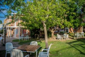 una mesa de madera y sillas bajo un árbol en El Cabure Complejo, en Villa Carlos Paz