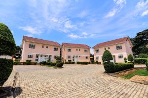a row of houses with a brick driveway at Corinya Serviced Apartments in Entebbe