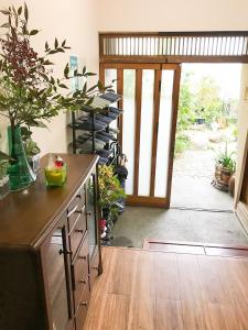 una stanza con tavolo con una pianta e una porta di Guesthouse Nishihara ad Atami