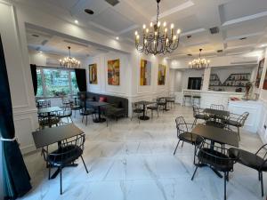 a dining room with tables and chairs and a chandelier at Venis Hotel in Tirana