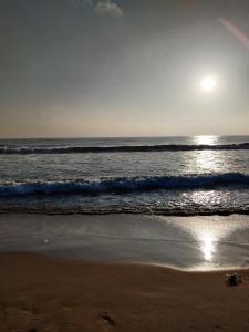 a beach with the sun rising over the ocean at Grand View Residency Chennai in Chennai