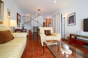 ein Wohnzimmer mit einer Couch und einem Tisch in der Unterkunft Villa De La Cruz in Playa Blanca