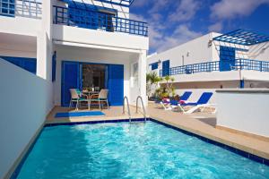 eine Villa mit einem Swimmingpool vor einem Haus in der Unterkunft Villa De La Cruz in Playa Blanca