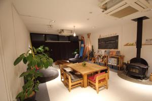 ein Wohnzimmer mit einem Tisch und einem Holzofen in der Unterkunft guest house Active Life -YADO- in Ishinomaki