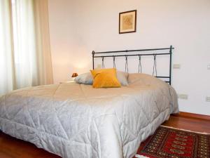 Una cama con una almohada naranja encima. en Residenza San Bortolo en Vicenza