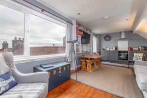 a living room with a couch and a large window at The Captain's Lookout - Cosy House with Sea Views in Anstruther