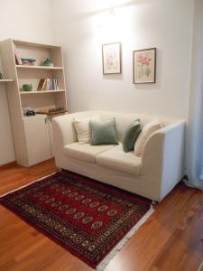 Residenza San Bortolo في فيتشنزا: أريكة بيضاء في غرفة معيشة مع سجادة