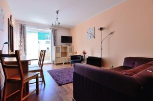 ein Wohnzimmer mit einem Sofa und einem Tisch in der Unterkunft Victus Apartamenty, Apartament Lumen in Sopot