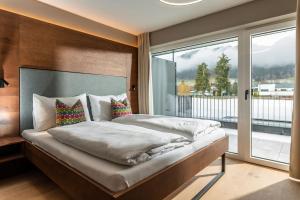 sypialnia z dużym łóżkiem i dużym oknem w obiekcie Appartements Wehrhof by Schladmingurlaub w Schladming