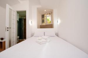 a white bed in a white room with two towels on it at Apartments on Chaykovskogo 16 in Odesa