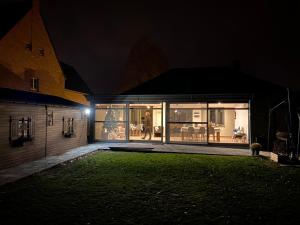 a house at night with a lawn in front of it at Vakantiewoning ‘t Reigersnest in Zonhoven