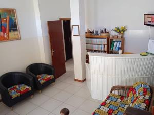 a living room with two chairs and a crib at Hotel AH Maio in Vila do Maio