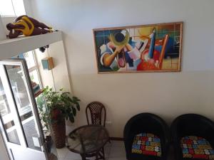 a living room with a painting on the wall at Hotel AH Maio in Vila do Maio