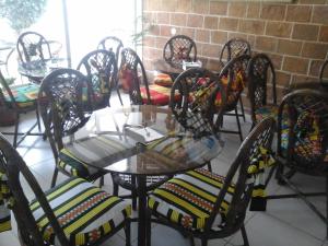a group of chairs and a glass table in a room at Hotel AH Maio in Vila do Porto